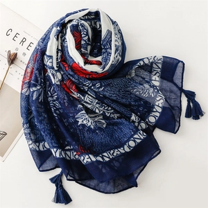 Detailed view of navy blue cotton linen scarf with red floral prints and fringe tassels