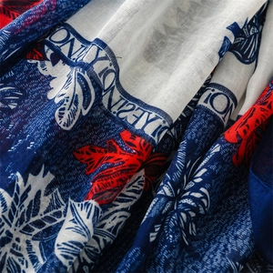 Macro shot of cotton linen texture scarf with navy tropical leaves and lettering