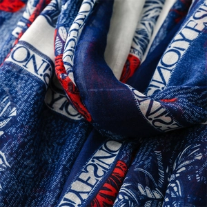 Macro shot of cotton linen texture scarf with red and blue leaf patterns and letter prints