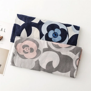 Detailed macro view of two camellia flower print scarves in navy and grey cotton linen