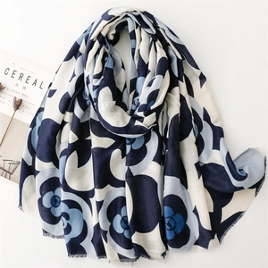 Detail of blue camellia print scarf with soft frayed fringe edges on a white background