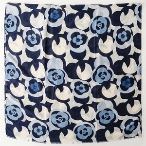 Macro detail of square floral scarf with blue camellia patterns and delicate fringe edges