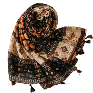 Bohemian geometric print cotton scarf with black tassels shown in a spiral fold
