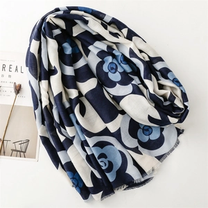 Detailed view of camel camellia print scarf with soft fringe edges and linen texture