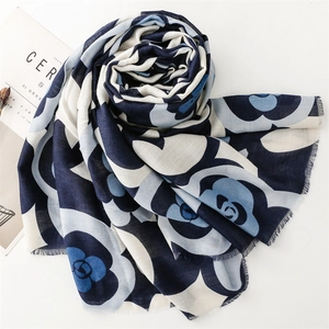 Detail of camellia floral print scarf with raw fringe edges and soft cotton-linen texture