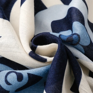 Macro shot of cotton linen scarf texture featuring khaki and navy camellia patterns