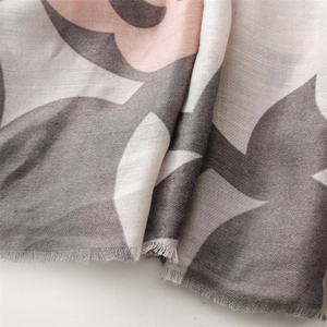 Close-up of pink and grey cotton linen scarf showing soft fringe edges and floral patterns