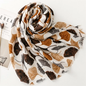 Detail of ginkgo leaf print on cotton-linen scarf with fine fringe edges and warm tones