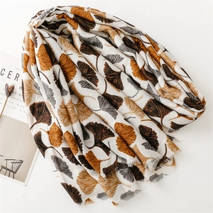 Detailed view of autumn cotton-linen scarf featuring artistic ginkgo leaf patterns