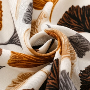 Macro shot of cotton linen scarf showing realistic white ginkgo leaf prints and fabric texture