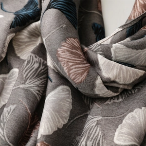 Detailed texture of cotton linen scarf featuring blue and white ginkgo leaf patterns