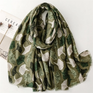 Olive green linen scarf featuring a white ginkgo leaf pattern and delicate tassel edges