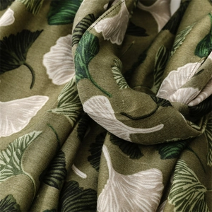 Detailed macro view of olive green linen-feel scarf with white ginkgo leaf patterns