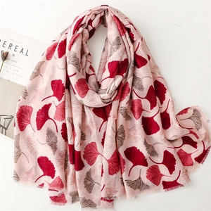 Detail of pink linen-feel scarf with red ginkgo leaf pattern and delicate fringe edges