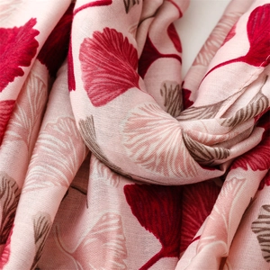 Macro shot of soft pink fabric with detailed red ginkgo leaf prints and fine texture