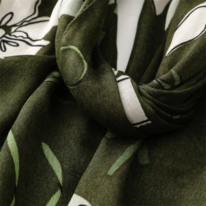 Macro di sciarpa in cotone verde scuro con motivi floreali beige e trama del tessuto