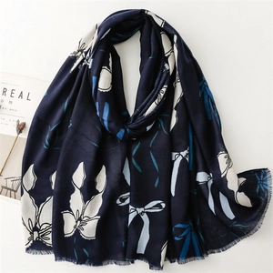 Dettaglio sciarpa in lino blu navy con stampa a farfalla e bordi sfrangiati morbidi