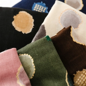 Gros plan d'une écharpe en coton multicolore avec motif à pois dorés élégants