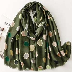 Écharpe vert foncé à pois multicolores, texture coton-lin et franges sur fond blanc pur