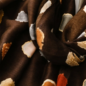 Détail macro du motif de feuilles tissées et de la couture fine sur le châle en coton-lin