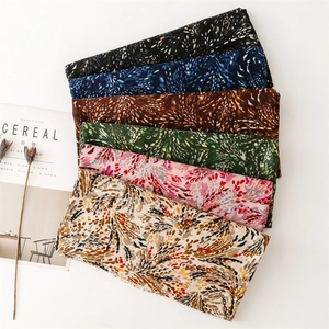 Close-up of lightweight satin scarves with golden wheat patterns in six elegant colors