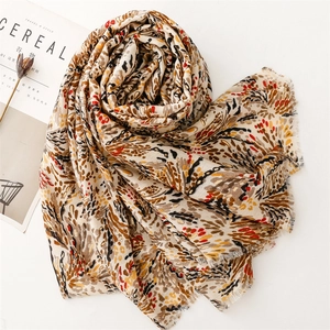 Detail of cotton linen scarf with golden wheat pattern and frayed edges for women