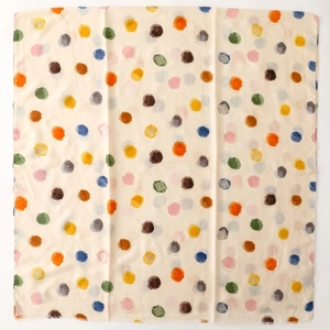 Détail de pois aquarelle colorés sur un foulard en satin beige au toucher lin doux