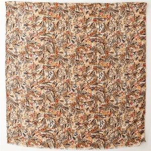 Macro view of beige cotton-linen scarf featuring golden abstract wheat and feather patterns