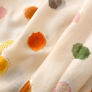 Détail d'écharpe beige avec touches dorées et motifs de pois colorés style aquarelle