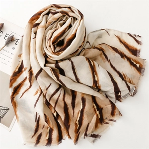 Detail of tiger print scarf featuring cotton linen texture and delicate fringe edges