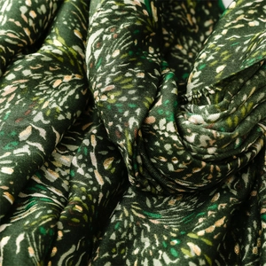 Macro detail of dark green cotton linen scarf with golden wheat ear foil pattern