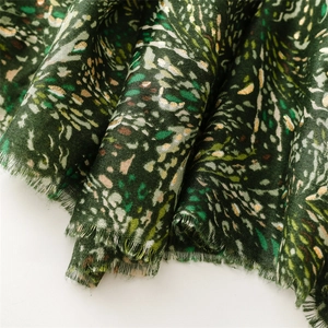 Macro detail of dark green cotton-linen scarf with golden foil wheat wave patterns