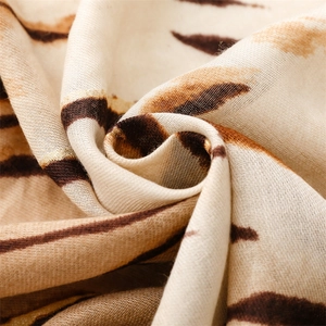Macro detail of zebra pattern scarf showing gold foil accents and soft texture