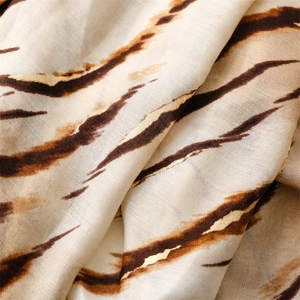 Detail of zebra pattern gradient scarf with golden metallic texture and woven fabric texture