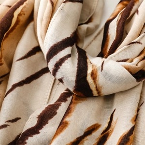Detailed macro view of zebra pattern gradient scarf with soft texture and golden threads