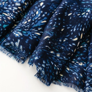 Detail of navy blue cotton-linen scarf with golden foil star pattern and frayed edges