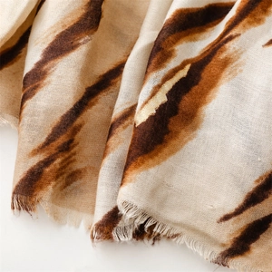 Detail of zebra pattern scarf with gold foil accents and soft frayed tassel edges
