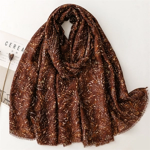 Close-up of brown cotton-linen scarf with gold foil print and fringe detail