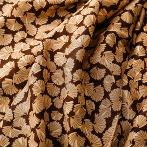 Detailed view of dark brown cotton-linen scarf with golden ginkgo leaf jacquard patterns