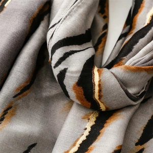 Macro shot of grey cotton shawl featuring golden zebra stripes and soft fabric texture