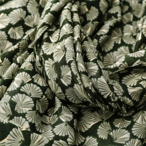 Detailed texture of dark green linen-feel scarf with golden ginkgo leaf patterns