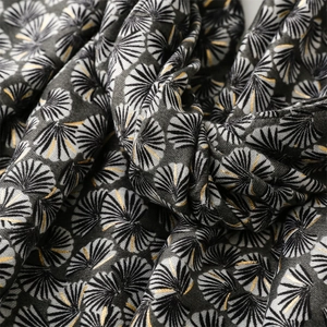 Close-up of deep gray cotton-linen scarf with golden ginkgo leaf patterns and fabric texture