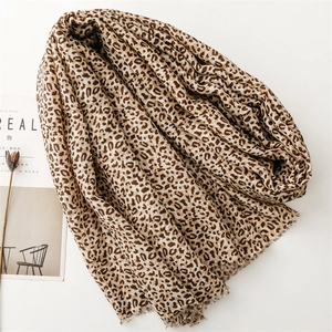 Close-up of leopard print scarf with fringed edges on a minimalist background