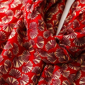 Macro shot of red cotton-linen scarf with silver gingko leaf foil patterns and soft texture