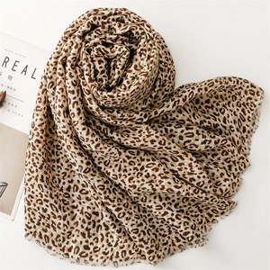 Detailed view of leopard print scarf with soft texture and frayed edges on white background