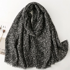 Long leopard print scarf in gray and black with raw fringe edges on a white background