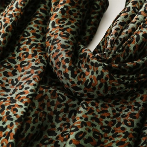 Macro view of dark green leopard print scarf with soft woven texture and fine leopard spots
