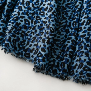 Close-up of electric blue leopard print scarf with soft fringed edges and satin texture