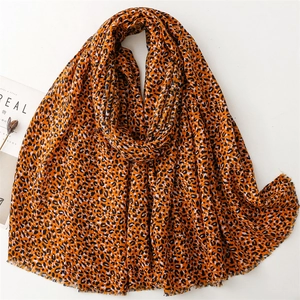 Detailed view of orange leopard print scarf with soft fringe edges and linen-like texture