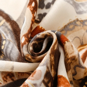 Macro shot of cotton linen scarf with geometric gold foil texture and warm earthy tones